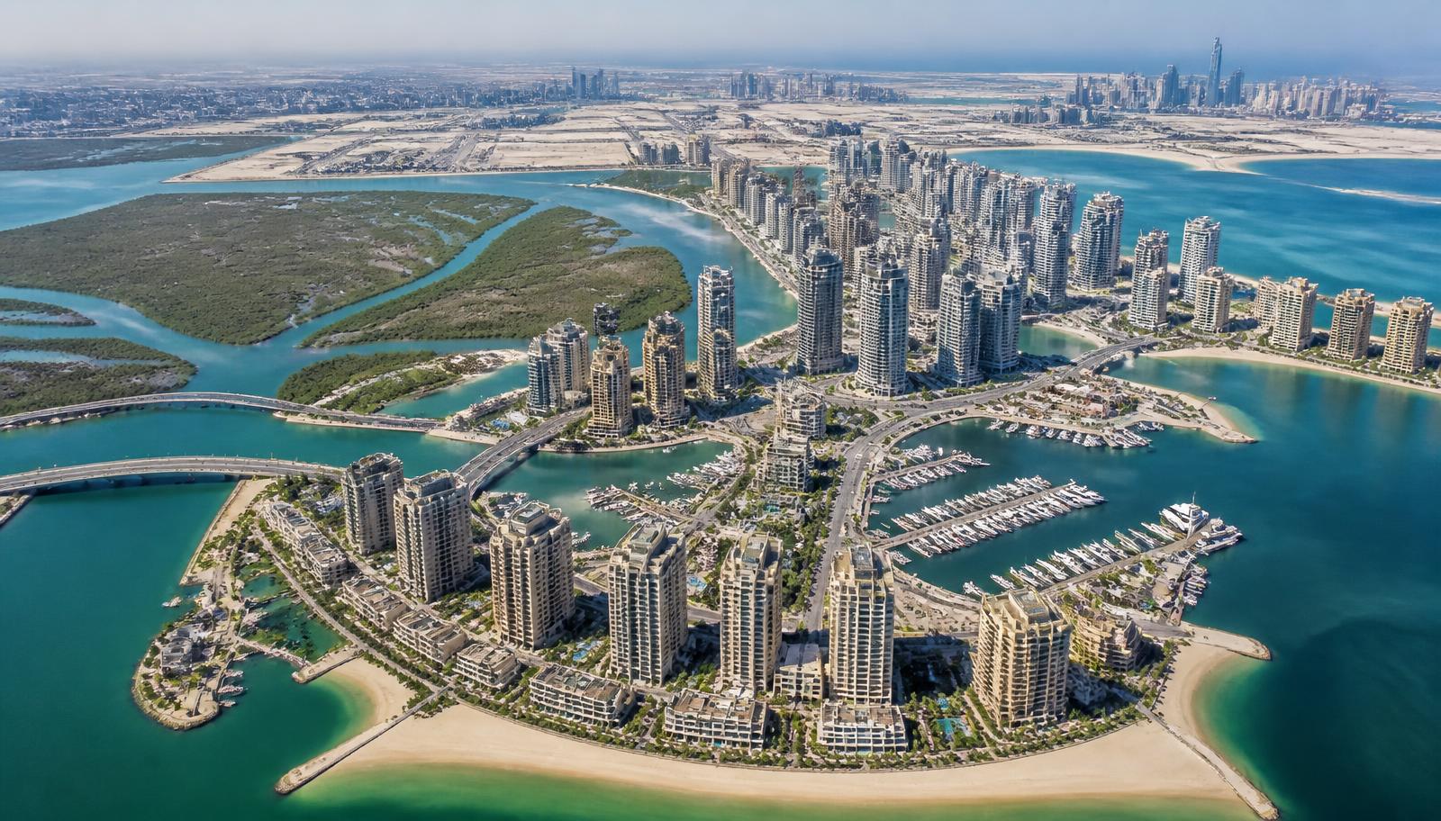 Luchtfoto van een eilandwijk in Abu Dhabi met woontorens, jachthaven, strand en mangroven
